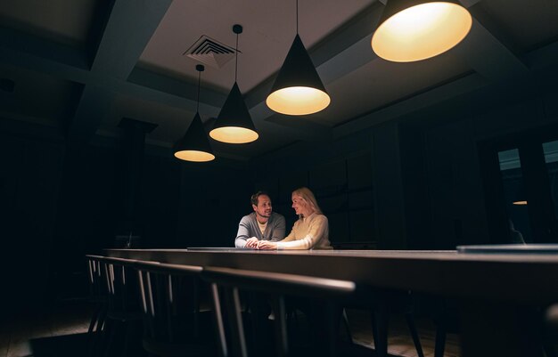 La coppia romantica seduta al tavolo nel ristorante notturno vuoto