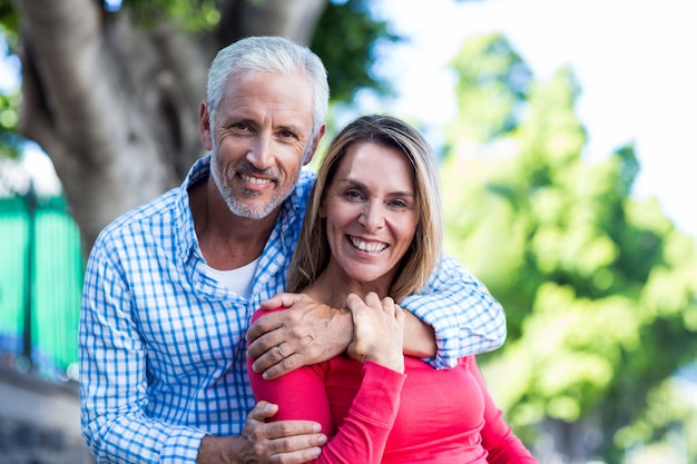  romantic couple standing against tree