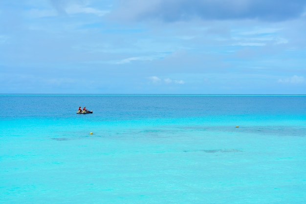 Romantic couple steering paddleboat on the sea in the beautiful day at Maldives Island