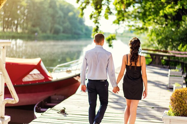 Coppia romantica che cammina sulla spiaggia giovane coppia interrazziale felice che cammina sulla spiaggia amandosi coppia di europei