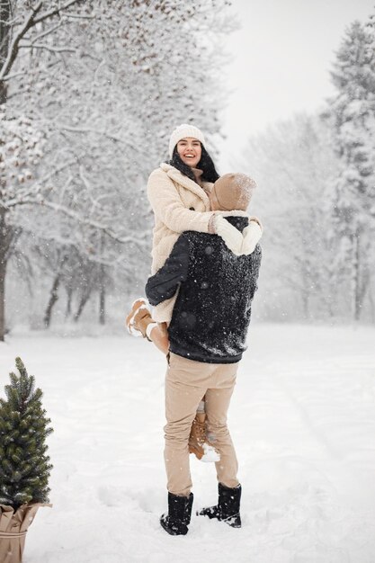 Romantic couple walking in forest at winter day