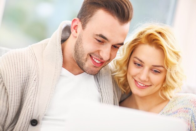 romantic couple with laptop in living room