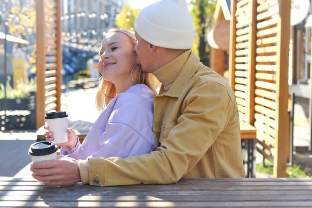 Romantic date for a couple a man hugs a girl from behind and
kisses her on the ear