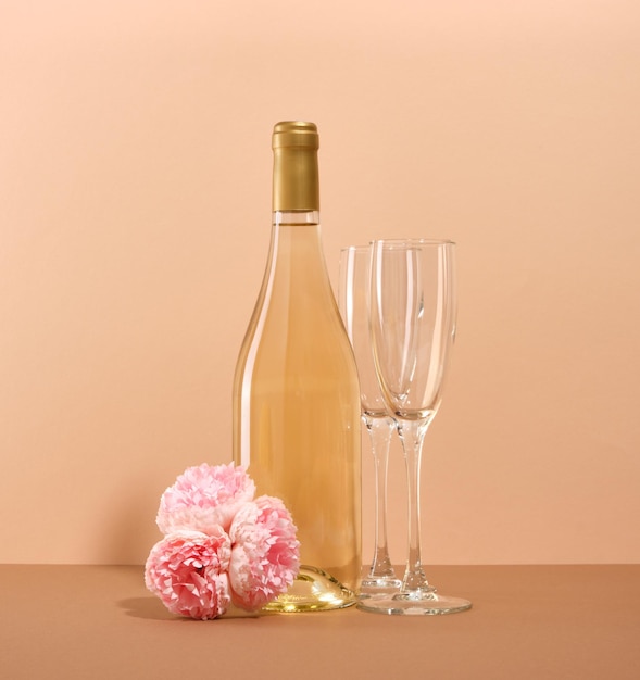 ロマンチックなディナーと愛のコンセプトおいしい白ワインのボトルと空のグラス 2 つおいしい香りの花
