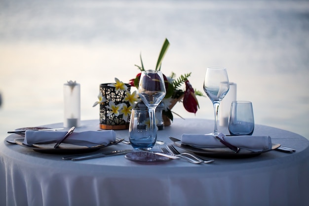 Romantic dinner setting on the beach at sunset