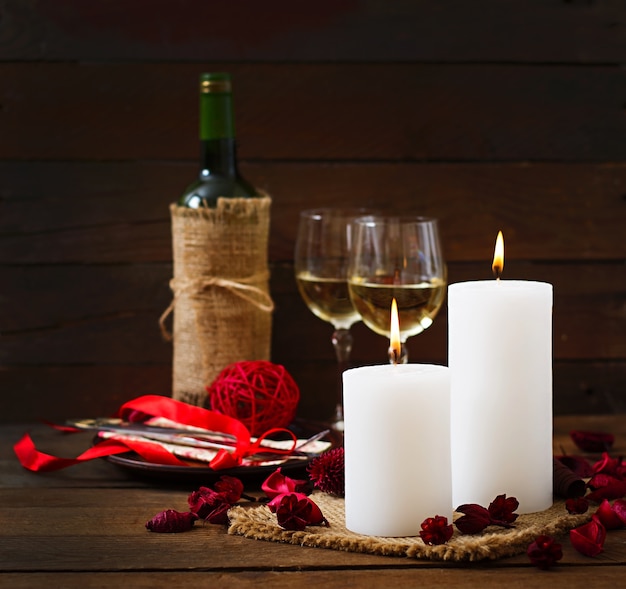 Romantic dinner setting, candles, wine and decor