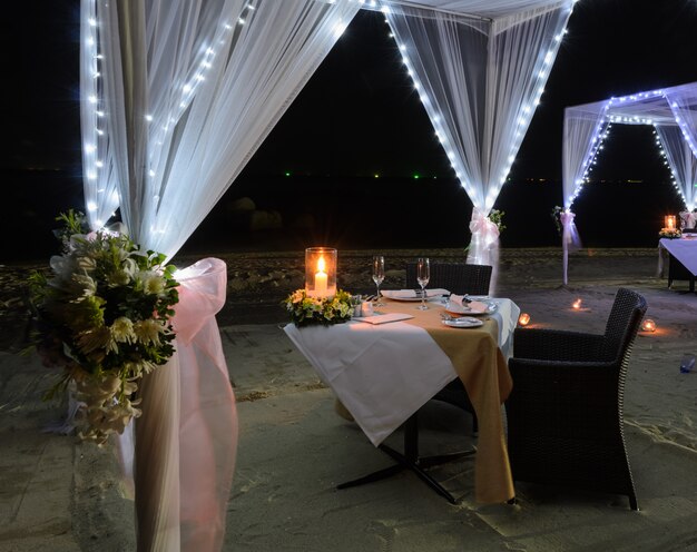 Photo romantic dinner setup on beach at night