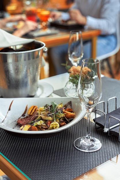 A romantic dinner in the summer on the deck of the ship at the bottom m with two glasses of white wine and a wine refrigerator.