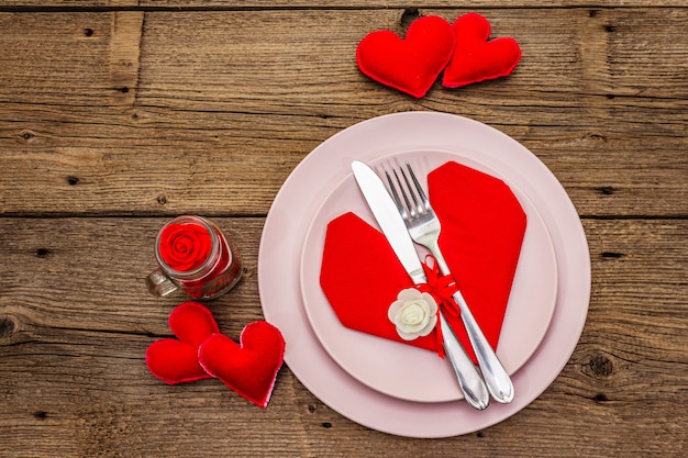 Romantic dinner table with plates and heart shape napkin