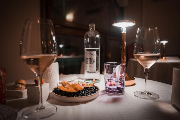 薄暗い部屋でワイングラスと食べ物でロマンチックでエレガントなテーブルセット