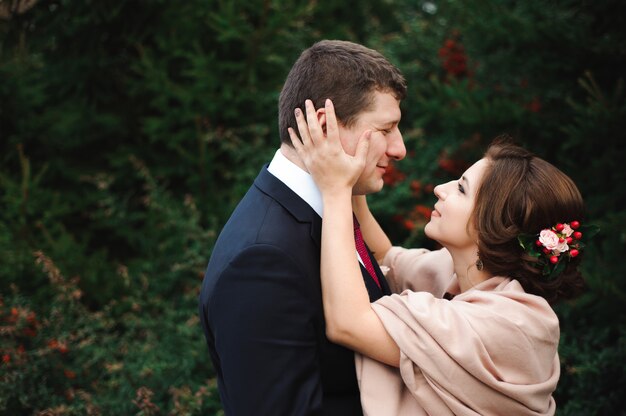 Romantic embrace of newlyweds. Couple walks in the park.