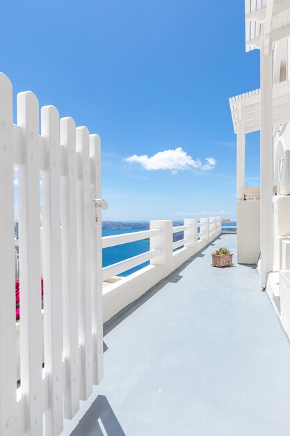 Romantic entrance white door and sea view under blue sky. Idyllic summer vacation destination Greece