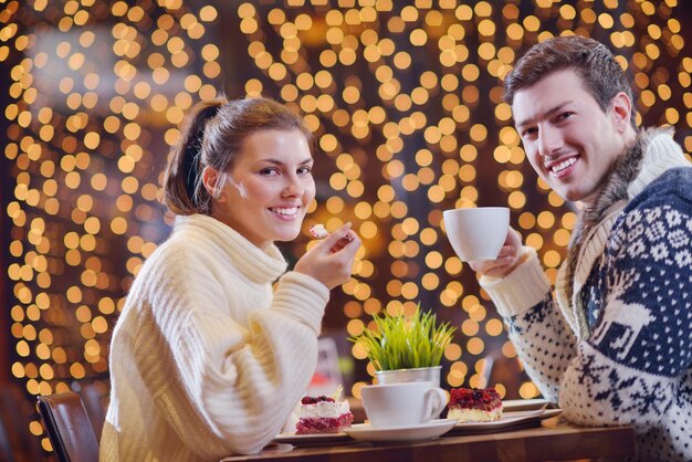 romantic evening date in restaurant  happy young couple with wine glass tea and cake