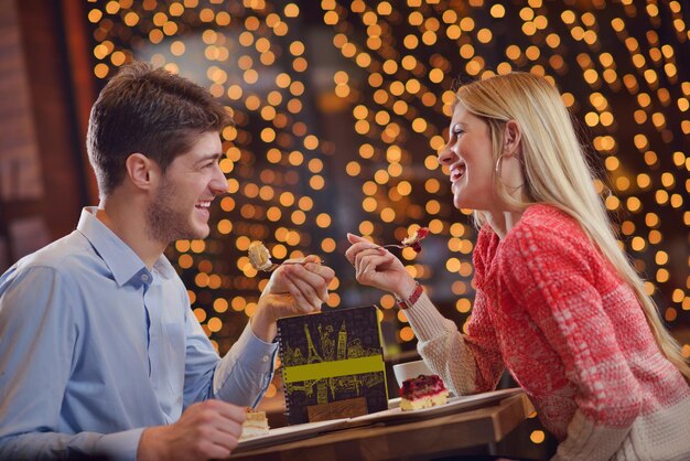 Romantic evening date in restaurant happy young couple with\
wine glass tea and cake