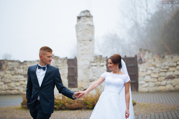 Romantic fairytale married couple holding hands in garden