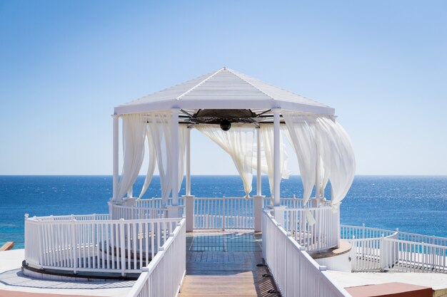 Romantic gazebo on the beach with blue sea