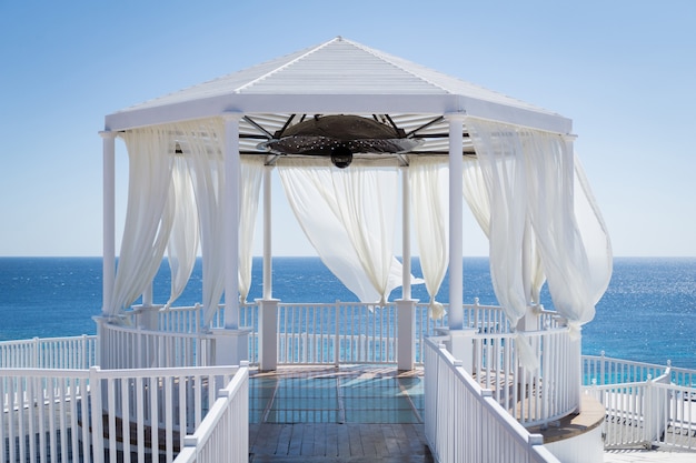 Romantic gazebo on the beach with blue sea