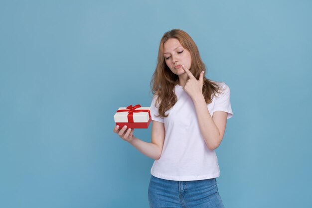 Romantic gift happy young woman opens valentines day gift on blue studio person