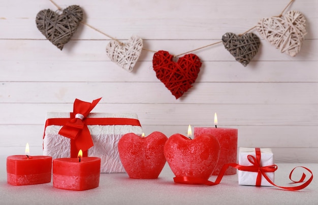木製の背景にキャンドルとロマンチックな贈り物。愛の概念