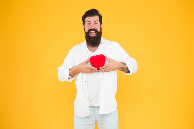 Romantic greeting bearded man red heart brutal hipster yellow background happy valentines day heart poblems and disease having healthy habits in lifestyle preventing heart attack fall in love