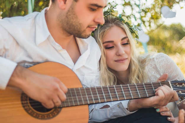 Un ragazzo romantico suona la chitarra e canta canzoni per il grande concetto d'amore della sua ragazza