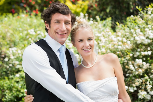 Romantic happy newlywed couple smiling at camera