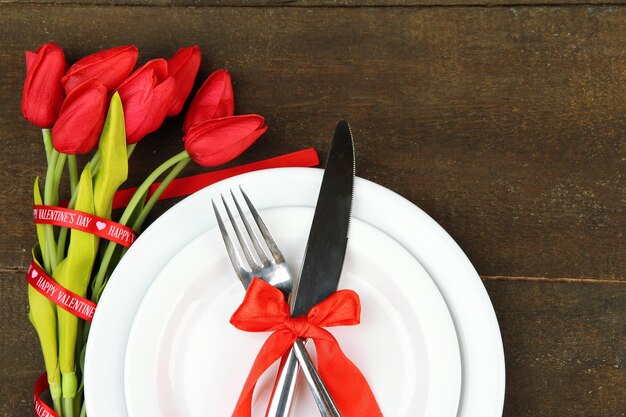 Romantic holiday table setting, on wooden background