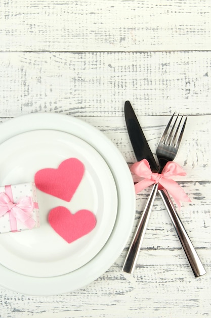 Romantic holiday table setting, on wooden background