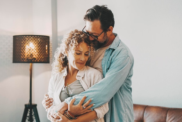 Amore romantico e relazione con la giovane coppia che si abbraccia a casa intimità e romanticismo con l'uomo e la donna della famiglia nuova emozione del concetto di felicità domestica persone che si godono il tempo insieme abbracciando la tenerezza