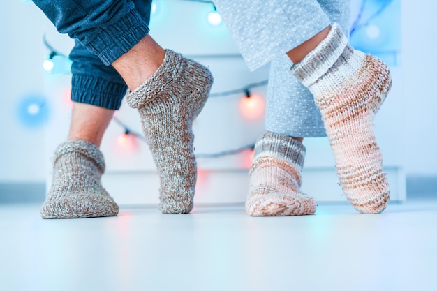 Romantic lovers family couple in warm knitted soft cozy socks in wintertime at home