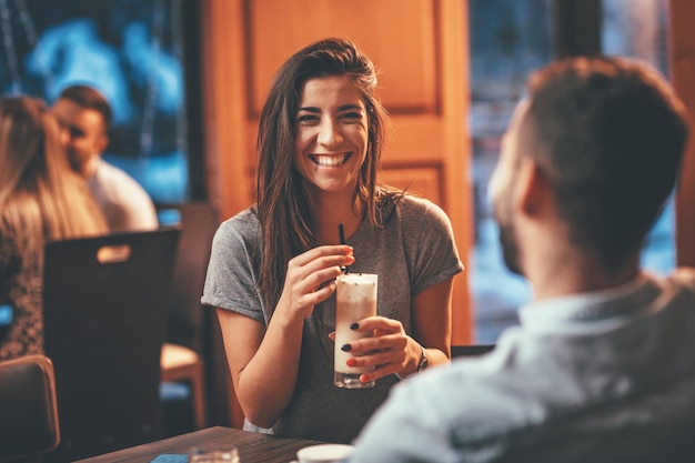 コーヒーを飲みながら、カフェでデートをするロマンチックな愛情のあるカップル。