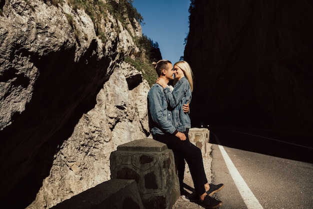 Romantic loving couple walking on the road with rocks and stones.