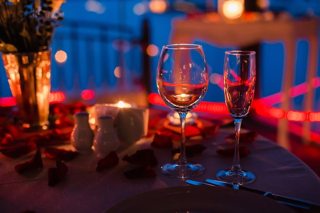 Romantic luxury evening with champagne setting with two glasses rose petails and candles