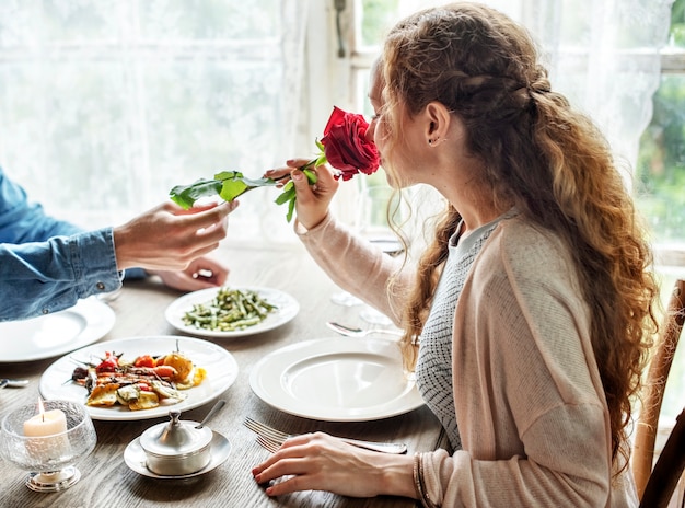 Uomo romantico che dà una rosa alla donna ad un appuntamento