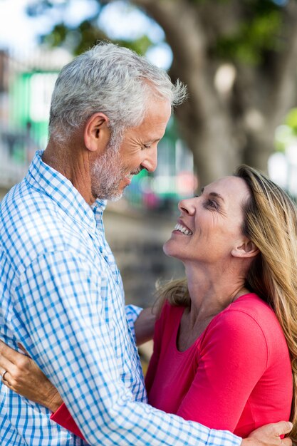 Romantic mature couple hugging by tree