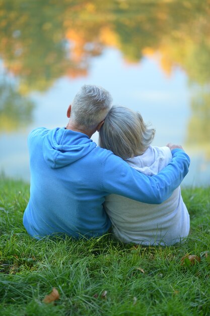 Foto coppia matura romantica seduta nel parco in autunno