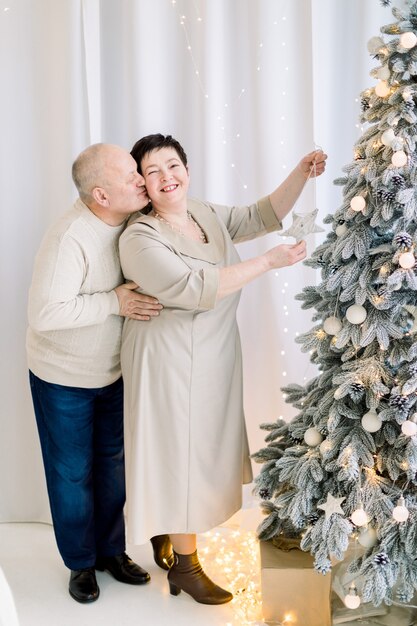 Romantic middle aged couple decorating Christmas tree