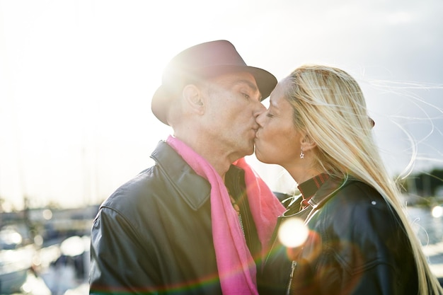 Romantic middleaged couple kissing in the harbor