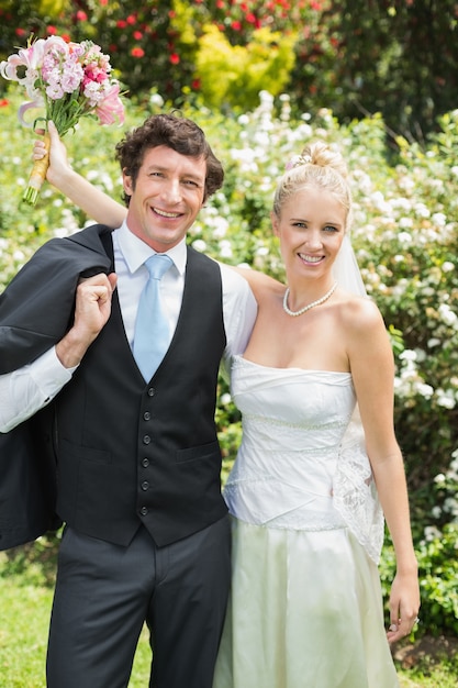 Romantic newlywed couple smiling at camera