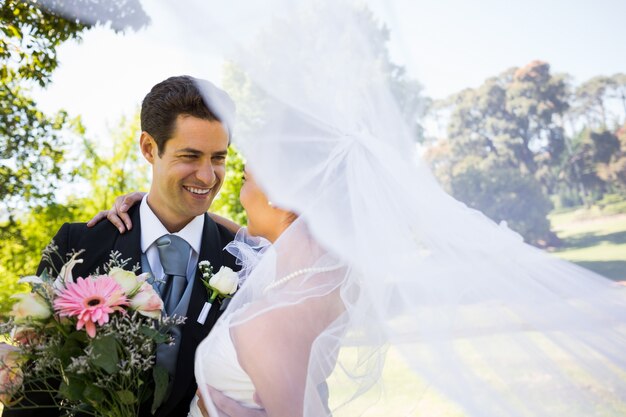 Romantic newlywed looking at each other in park