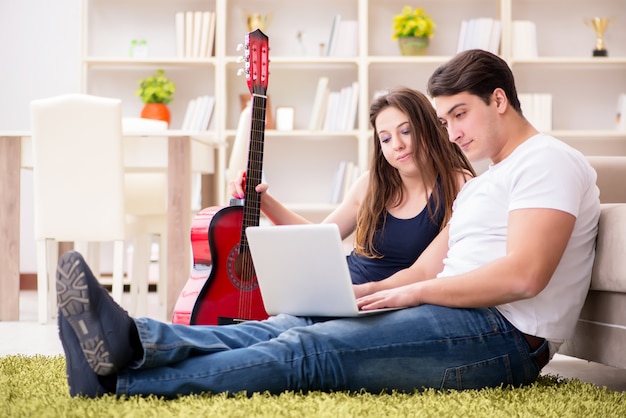 Romantic pair playing guitar on floor