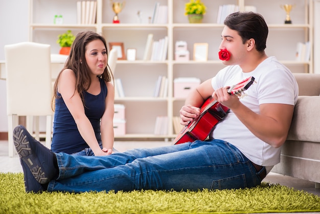 Foto coppia romantica suonando la chitarra sul pavimento