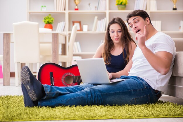 Foto coppia romantica suonando la chitarra sul pavimento