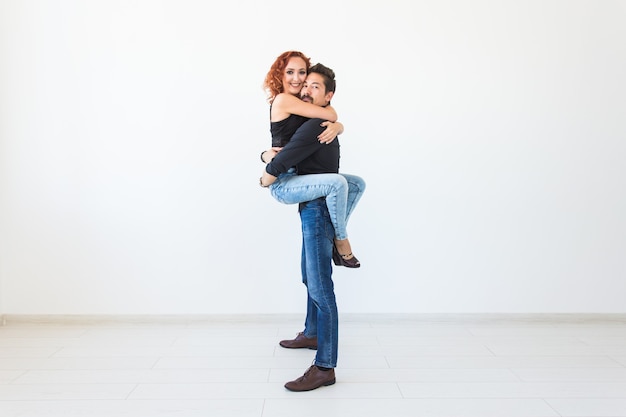 Romantic, passion, people concept - young couple dancing with passion on white wall with copy space