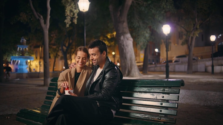 Photo romantic people flirting evening date eating strawberry in urban park together