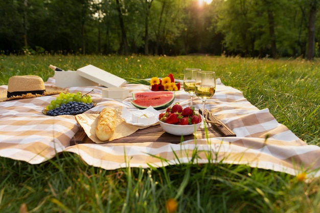 Romantic picnic in nature. The beauty of the setting sun, fresh fruits and wine.