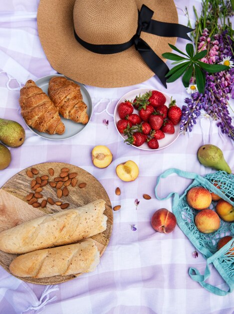 Scena di picnic romantico il giorno d'estate. picnic all'aperto con vino e frutta all'aperto sullo sfondo dell'erba verde.