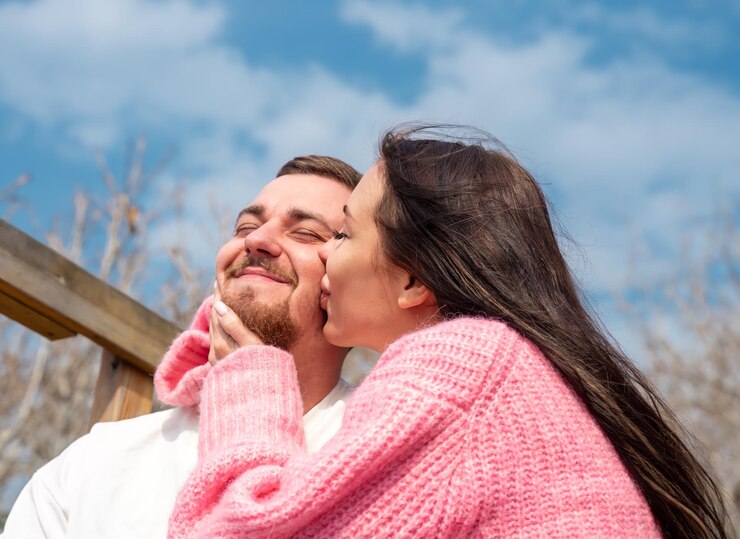 若い結婚したロシア人カップルのロマンチックな肖像画夫にキスする女性