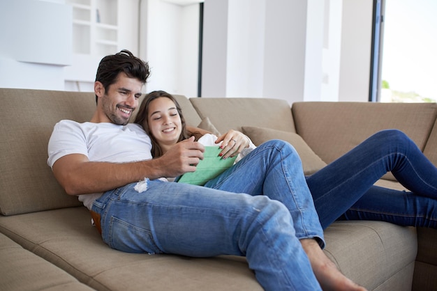 Photo romantic relaxed young couple at modern home using tablet computer