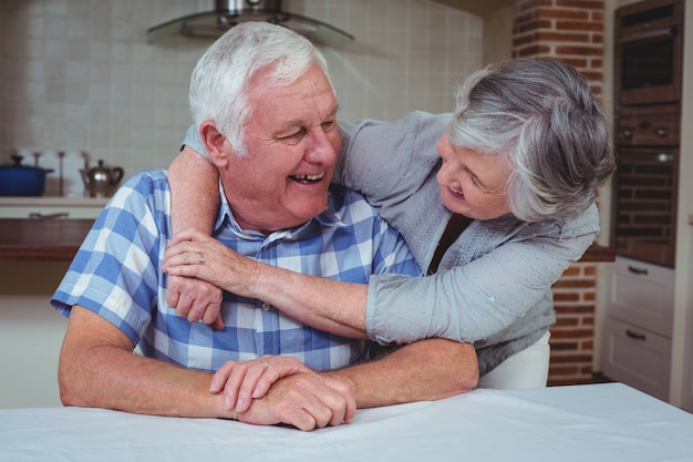 Romantic senior couple embracing in kitchen